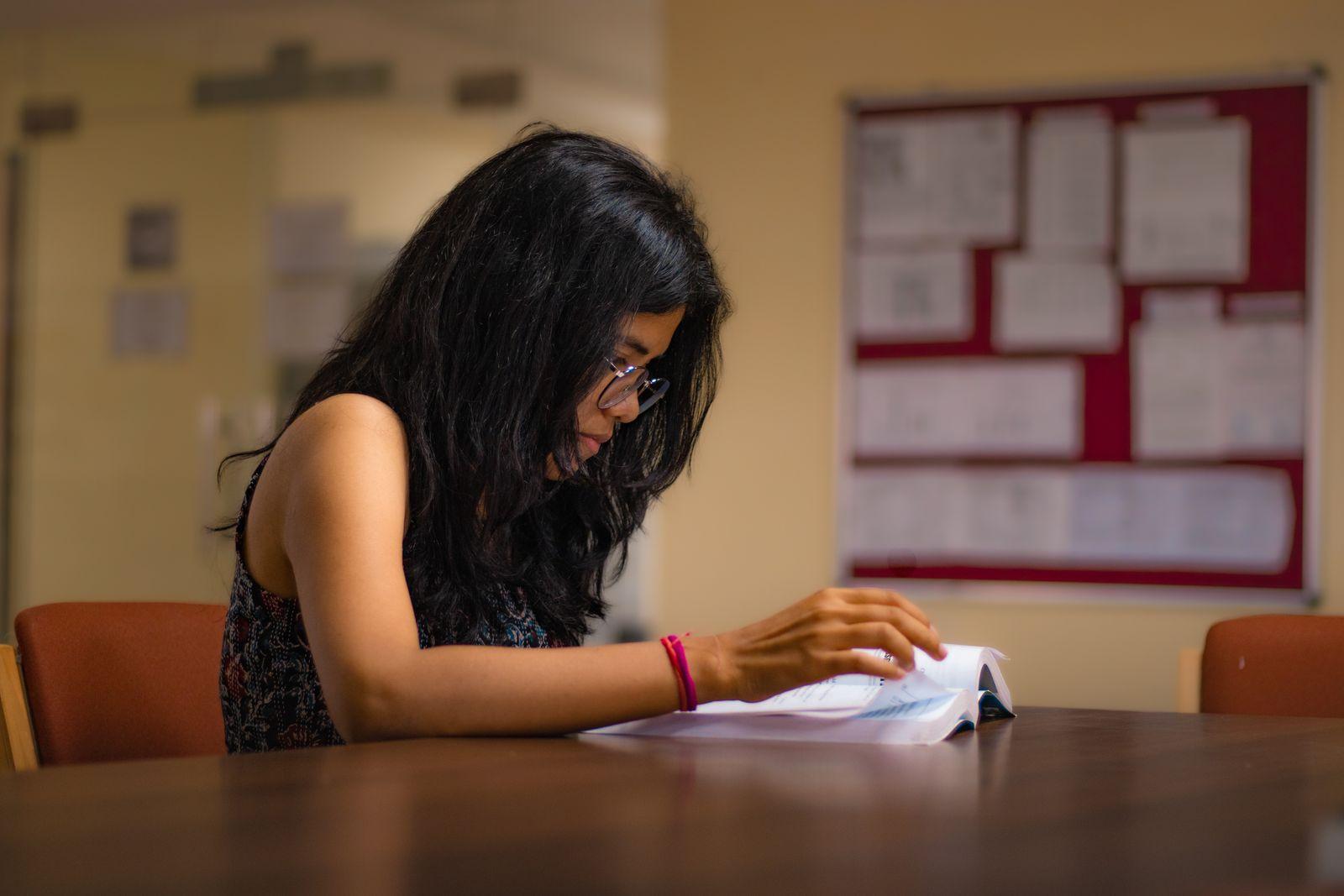 A student reading at a library table